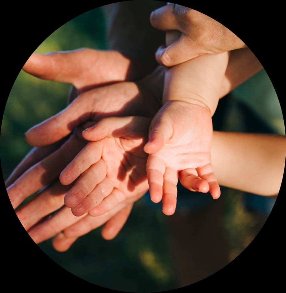 Manos adultas e infantiles en contexto de cuidado familiar