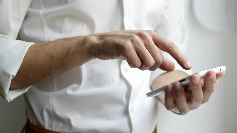 Persona documentant acords de custòdia al seu telèfon mòbil